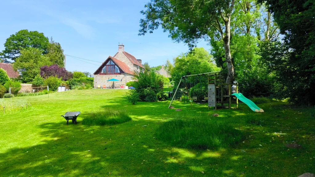 Aire de jeux enfants gîte normandie avec balançoires, toboggan et équipements sécurisés