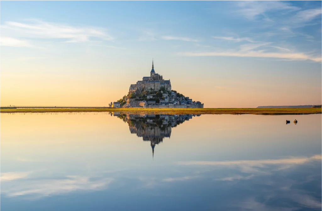 Activités en Normandie avec la visite du Mont-Saint-Michel et son reflet dans l’eau au coucher du soleil