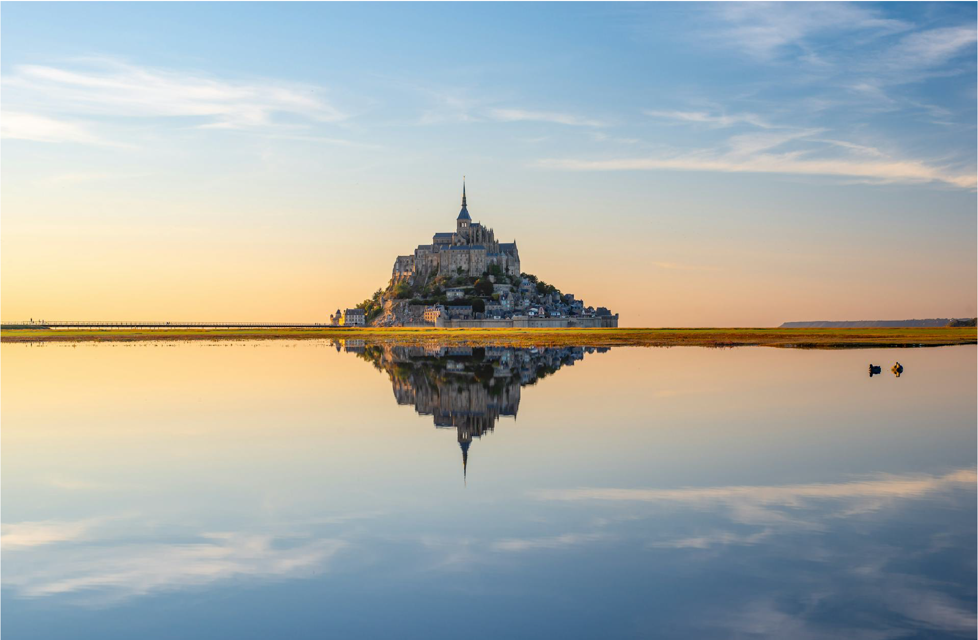 Activités en Normandie avec la visite du Mont-Saint-Michel et son reflet dans l’eau au coucher du soleil
